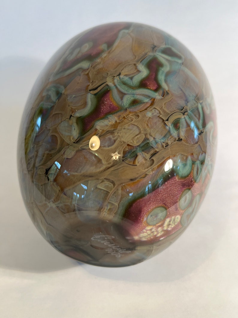 Pu&ograve; includere: Una sfera di vetro marrone, verde e rosa con motivi a spirale. La sfera &egrave; firmata "Chihuly" sul fondo.