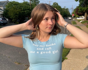 Camiseta corta Y2K con la frase "Cómprame libros y llámame buena chica"