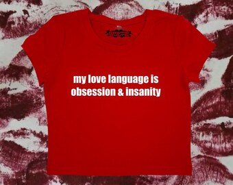 May include: Red cropped t-shirt with white text that reads "my love language is obsession & insanity".