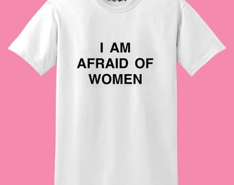 May include: White t-shirt with black text that reads "I AM AFRAID OF WOMEN".