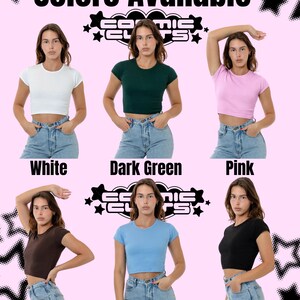 May include: Image showcasing a variety of crop tops in different colors: white, dark green, pink, brown, baby blue, and black. The text "Colors Available" is at the top, with the brand logo and color names below each top. The tops are paired with blue jeans.