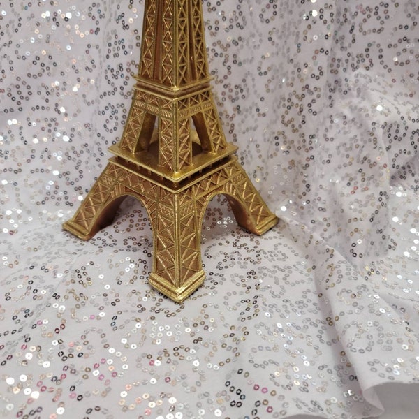 Tela de lentejuelas plateadas: Jersey de punto blanco elástico. Se vende cortada a medida.