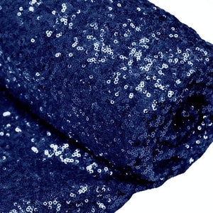 Puede incluir: Primer plano de una tela azul marino cubierta de lentejuelas. Las lentejuelas son pequeñas y están muy juntas, creando un efecto brillante.