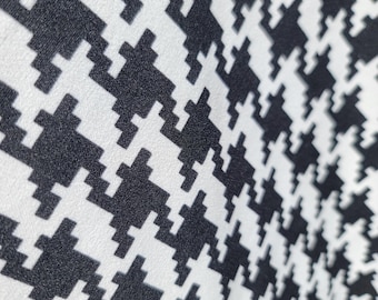 May include: Black and white houndstooth fabric with a textured surface.