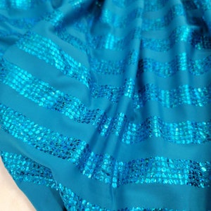 May include: Teal blue fabric with horizontal stripes of turquoise sequins.