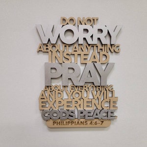 May include: A wooden wall decor with the words "Do Not Worry About Anything Instead Pray About Everything And You Will Experience Gods Peace Philippians 4:6-7" in gold and silver lettering.