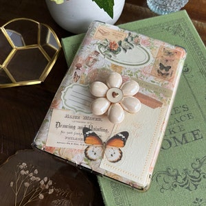 May include: A white and gold floral phone case with a butterfly design and the text "Alice Miner, Teacher of Drawing and Painting, No. 5206 Germantown, Pa.  U.S.A."