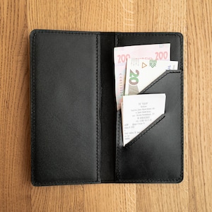 May include: A black leather wallet with a receipt and two bills of Russian currency inside. The bills are 200 roubles and 20 roubles.