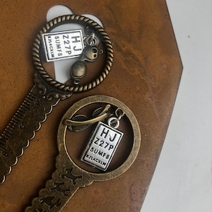 Circle top antique gold pd ruler with hanging glasses and eye chart charms