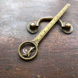 Circle top antique gold pd ruler with hanging glasses and moon/star charms