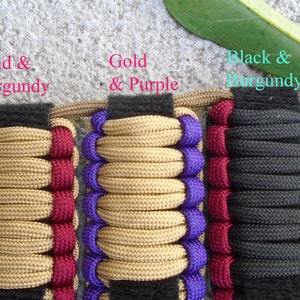 May include: Three paracord bracelets with different color combinations. The first bracelet is gold and burgundy, the second is gold and purple, and the third is black and burgundy.