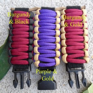 May include: Three paracord bracelets with black clasps. The bracelets are made with burgundy and black paracord, purple and gold paracord, and burgundy and gold paracord. The text "Burgundy & Black", "Purple & Gold", and "Burgundy & Gold" is written on the bracelets.