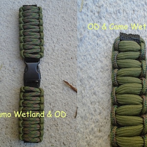 May include: Two green and brown camouflage paracord watch bands with black buckles. The band on the left is labeled "Camo Wetland & OD". The band on the right is labeled "OD & Camo Wetland".