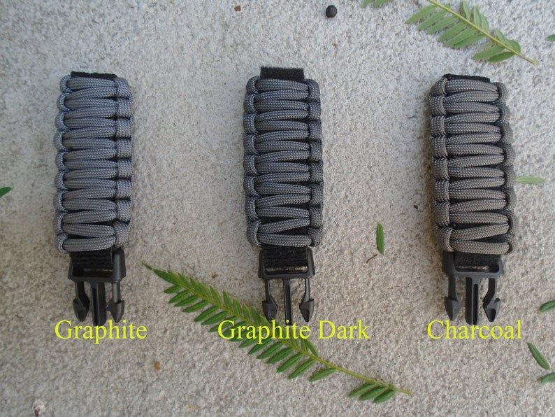May include: Three grey paracord straps with black buckles. The straps are labelled "Graphite", "Graphite Dark", and "Charcoal".