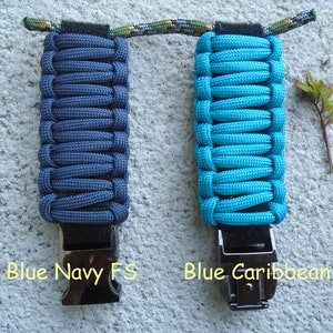 May include: Two paracord keychains, one in navy blue and one in turquoise blue, with black metal clasps. The text "Blue Navy FS" is below the navy blue keychain and "Blue Caribbean" is below the turquoise blue keychain.