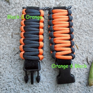 May include: Two paracord bracelets with black and orange woven patterns. The bracelets have black plastic buckles.