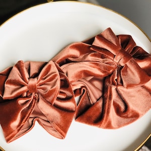 Puede incluir: Dos diademas de terciopelo marr&oacute;n con lazos. Las diademas est&aacute;n hechas de una tela suave y lujosa y son perfectas para agregar un toque de elegancia a cualquier atuendo.