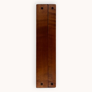 May include: Two wooden panels joined together with black metal hinges. The panels are a rich brown color and have a smooth, polished finish. Each panel has two black metal screws at the top and bottom.