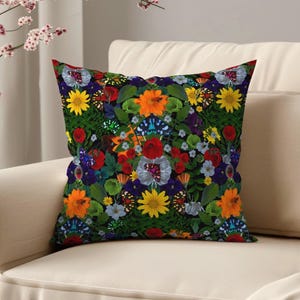 Op de afbeelding: Vierkant sierkussen met een levendig bloemen- en vlinderpatroon. Het ontwerp heeft een donkere achtergrond met kleurrijke bloemen in rood, geel, oranje en paars, samen met vlinderaccenten. Het kussen ligt op een crèmekleurige bank.