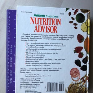 May include: A green and white book titled "Prevention Magazine's Nutrition Advisor" with a red and white barcode on the back. The book cover features a colorful image of various fruits and vegetables.