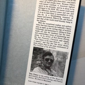 K&ouml;nnte beinhalten: Ein Buchcover mit einem Foto von Tom Clancy, dem Autor von "Jagd auf Roter Oktober", "Roter Sturm Aufzieht" und "Patriot Games". Das Cover ist blau und wei&szlig; mit dem Text "G.P. Putnam's Sons Publishers Since 1838 200 Madison Avenue New York, NY 10016".