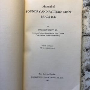 May include: Open book titled "Manual of Foundry and Pattern Shop Practice" by Otis Benedict, Jr. The book is a first edition, third impression, published in 1947 by McGraw-Hill Book Company, Inc. in New York and London.