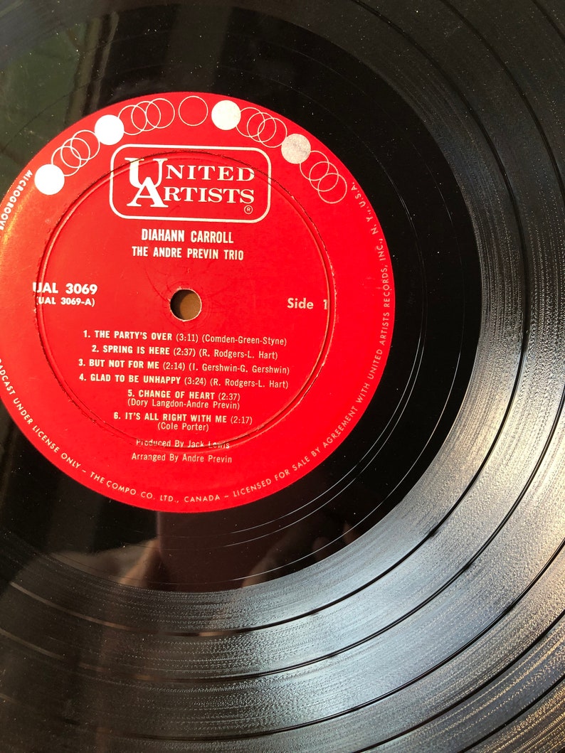 May include: A red vinyl record with the title "The Party's Over" by Diahnne Carroll and The Andre Previn Trio. The record is from United Artists Records and is labeled as side 1. The record is a 33 1/3 RPM record.