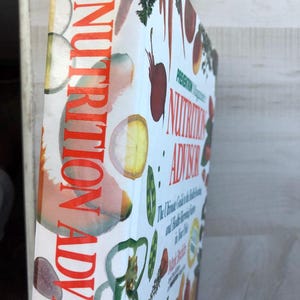 May include: A book titled "Prevention Magazine's Nutrition Advisor: The Ultimate Guide to the Best Foods and Health-Boosting Strategies for Life" with a colorful cover featuring various fruits and vegetables.