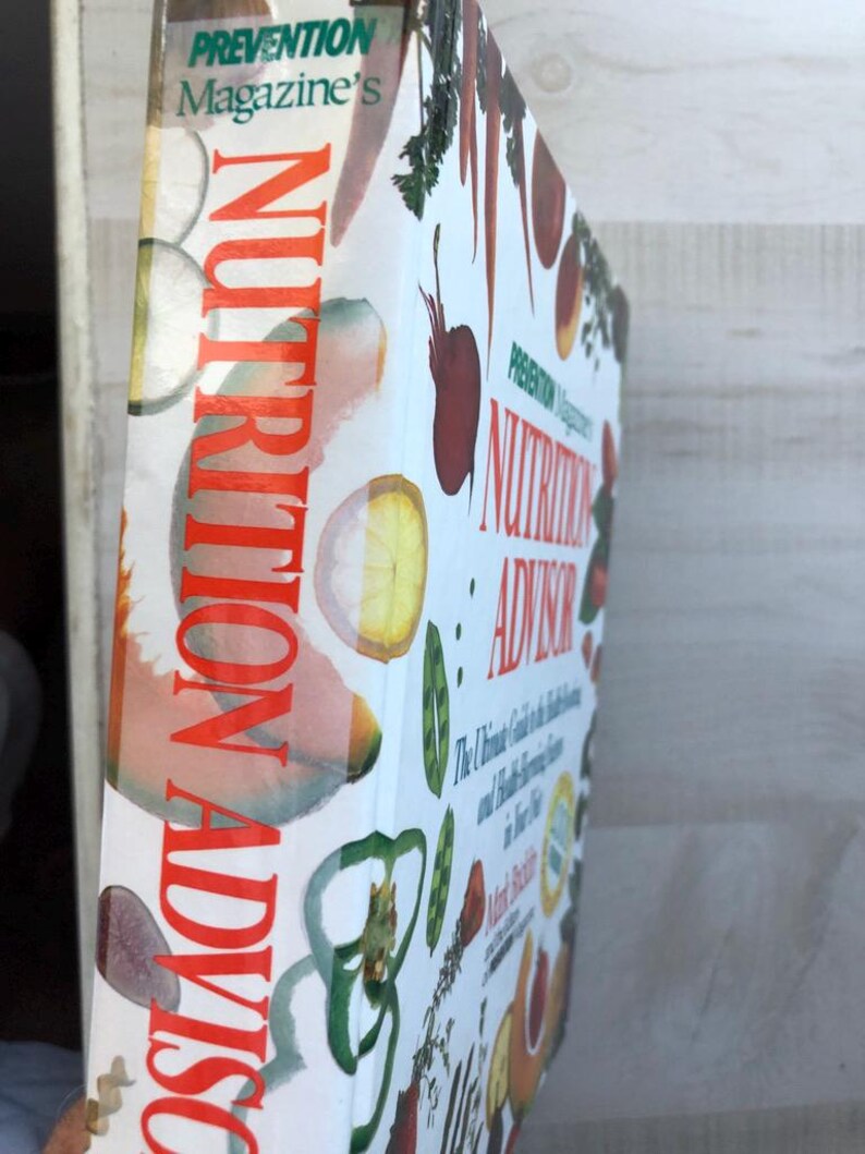 May include: A book titled "Prevention Magazine's Nutrition Advisor: The Ultimate Guide to the Best Foods and Health-Boosting Strategies for Life" with a colorful cover featuring various fruits and vegetables.