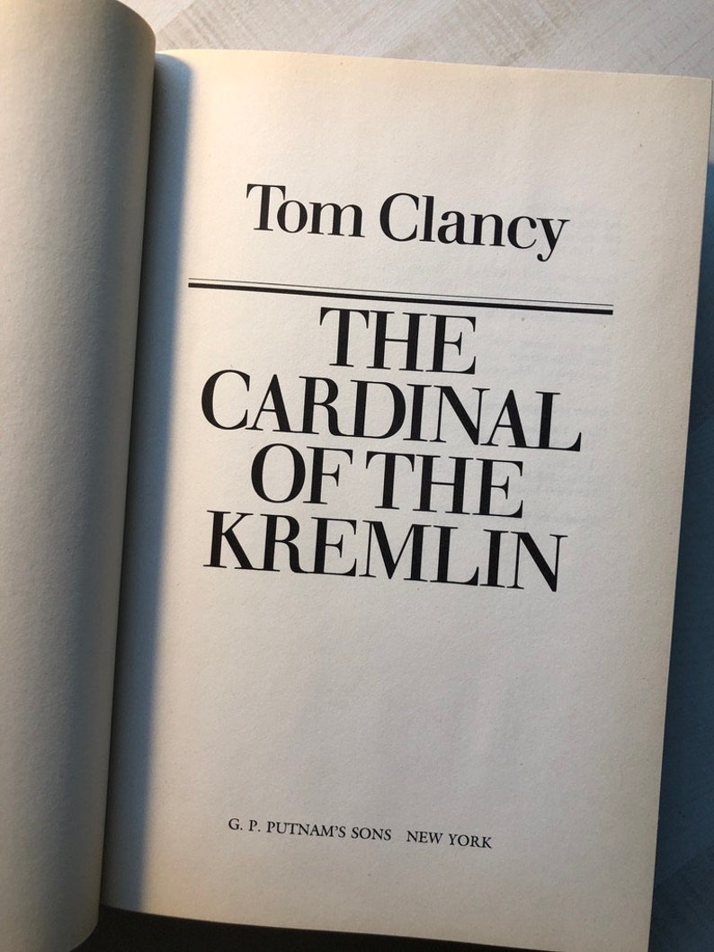 K&ouml;nnte beinhalten: Ein Buchcover mit dem Titel "Der Kardinal des Kremls" von Tom Clancy. Das Buch wurde von G. P. Putnam's Sons in New York ver&ouml;ffentlicht.