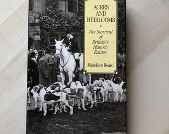 Könnte beinhalten: Schwarzweißes Fotobuchcover mit dem Titel "Acres and Heirlooms: The Survival of Britain's Historic Estates" von Madeleine Beard. Das Cover zeigt eine Gruppe von Menschen und Hunden vor einem Gebäude.