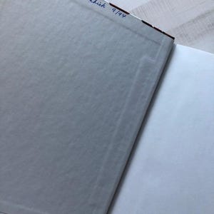 May include: The back cover of a book with a white background and a floral pattern. The book is signed "Dorothy E. Wachik 9/94".