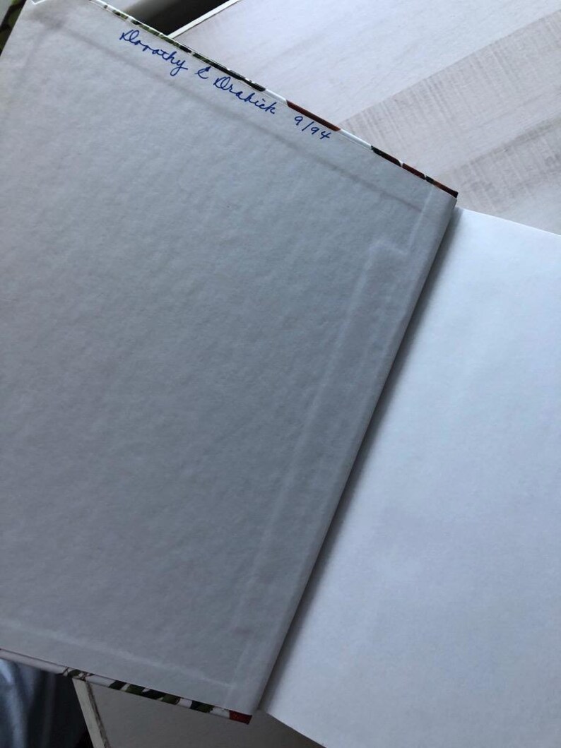 May include: The back cover of a book with a white background and a floral pattern. The book is signed "Dorothy E. Wachik 9/94".