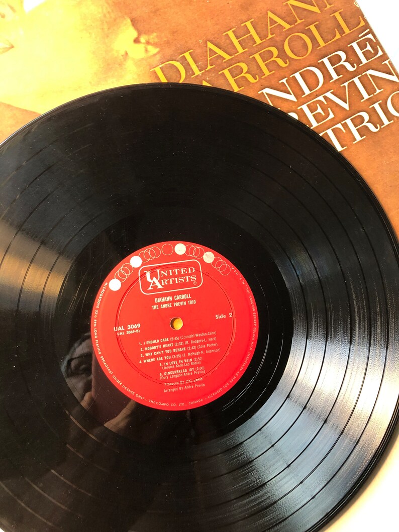May include: A black vinyl record with a red label. The label has the text "United Artists" and "Diann Carroll" with the title "The Andre Previn Trio". The record is labeled "Side 2" and has the song titles "I Should Care", "Nobody's Heart", "Why Can't You Behave", "Where Are You", "In Love In Vain", "Sing, Sing, Sing", "Everybody's Got Joy", and "The Sing-Along Joy (2:00)".