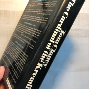 K&ouml;nnte beinhalten: Der hintere Umschlag eines Taschenbuchs mit dem Titel "Der Kardinal des Kremls" von Tom Clancy. Der Umschlag ist schwarz mit wei&szlig;em Text. Das Buch ist Teil einer Reihe und enth&auml;lt Zitate aus Rezensionen anderer B&uuml;cher der Reihe.