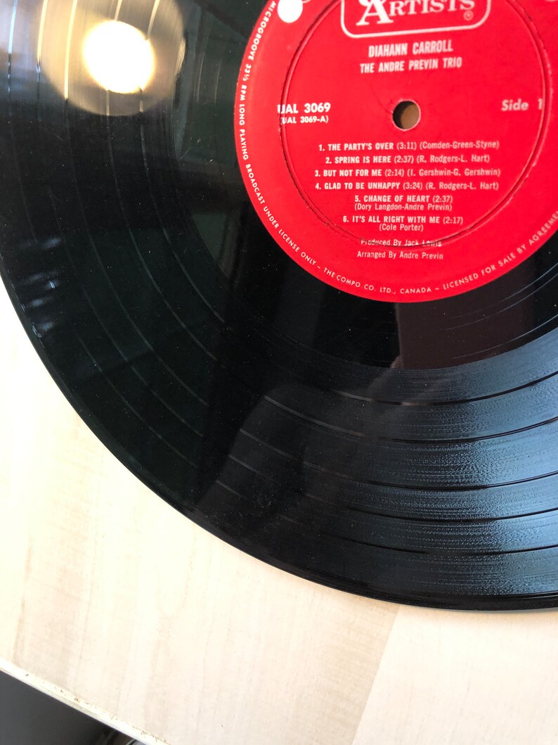 May include: A red vinyl record with the title "The Party's Over" by Diahann Carroll and The Andre Previn Trio. The record is labeled "IJAL 3069" and "Side 1".
