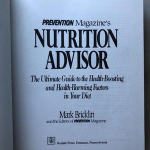 May include: A book titled "PREVENTION Magazine's NUTRITION ADVISOR: The Ultimate Guide to the Health-Boosting and Health-Harming Factors in Your Diet" by Mark Bricklin and the Editors of PREVENTION Magazine. The book cover is white with black text and a small logo at the bottom.