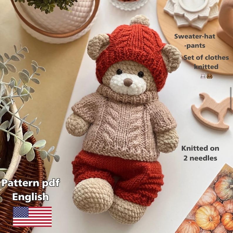 May include: A knitted teddy bear wearing a red hat, sweater, and pants. The bear's outfit includes a light brown cable-knit sweater and red pants. The text "Pattern pdf English" is visible.