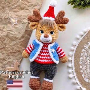 May include: A handmade crochet reindeer doll wearing a red and white striped sweater, blue vest, and a red Santa hat. The doll has brown antlers, gray pants, and brown boots. The text "Pattern crochet English" is visible.