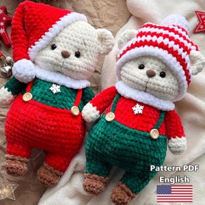 May include: Two handmade crochet teddy bears dressed in Christmas outfits. One bear wears a red Santa hat and the other a red and white striped hat. Both bears have red and green outfits with snowflake accents.