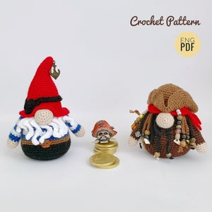 Puede incluir: Dos gnomos piratas de crochet, uno con un sombrero rojo y el otro con un sombrero marrón, ambos con barbas y accesorios de pirata. El gnomo con el sombrero rojo sostiene una pequeña moneda de oro. El gnomo con el sombrero marrón lleva una bandana roja y tiene un sombrero de calavera y huesos cruzados en el suelo delante de él.