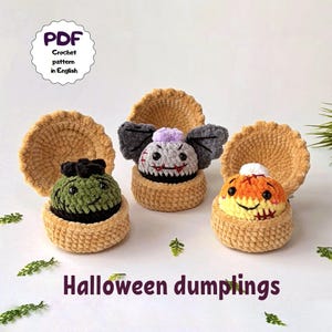 Puede incluir: Tres dumplings de Halloween tejidos a ganchillo en conchas abiertas de color beige. Uno es verde con pelo negro, uno es gris con alas de murciélago y pelo morado, y uno es naranja con pelo blanco. Texto: PDF Crochet pattern in English y Halloween dumplings.
