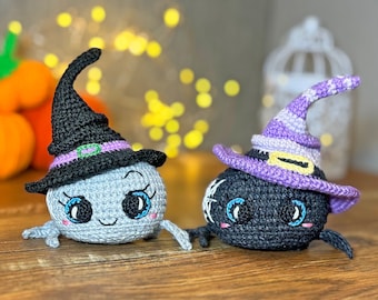 May include: Two crocheted Halloween spider toys. One is black with a purple witch hat and the other is gray with a black witch hat. Both have googly eyes and a smiling expression.