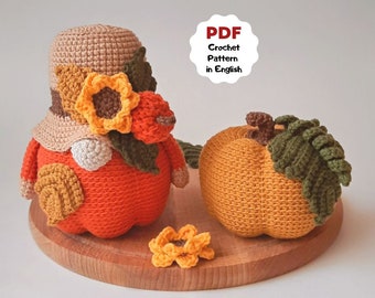 May include: Two crocheted pumpkins, one wearing a brown crocheted hat with a yellow crocheted flower. The pumpkins are sitting on a wooden surface. PDF Crochet Pattern in English.