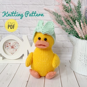Pode incluir: Padrão de tricô para um pato amarelo usando um chapéu verde claro. O padrão está disponível em inglês e é um download PDF.