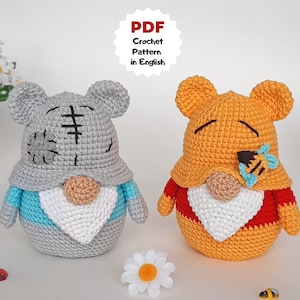 K&ouml;nnte beinhalten: Zwei geh&auml;kelte Gnom-Puppen, eine graue mit einer blau-wei&szlig;en M&uuml;tze und die andere orange mit einer rot-wei&szlig;en M&uuml;tze. Der graue Gnom hat ein aufgesticktes Gesicht und der orange Gnom hat eine Biene auf seiner M&uuml;tze. PDF H&auml;kelanleitung auf Englisch.