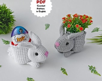 May include: Two crocheted bunny planters, one white with a chocolate egg inside and one gray with a small potted plant. Both bunnies have pink noses and black eyes.