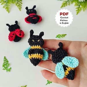 May include: Crocheted insect pattern in English. The image shows three small, handmade crochet insects: a ladybug with red wings, a bee with yellow and black stripes, and a black insect with blue wings. The text "PDF Crochet Pattern in English" is also visible.