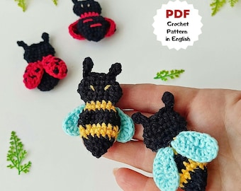 May include: Crocheted insect pattern in English. The image shows three small, handmade crochet insects: a ladybug with red wings, a bee with yellow and black stripes, and a black insect with blue wings. The text "PDF Crochet Pattern in English" is also visible.