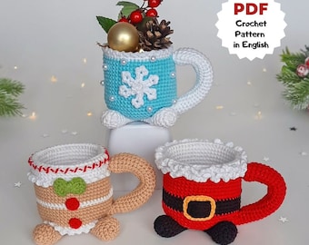 May include: Three crocheted mugs, one blue with a snowflake design, one gingerbread man design, and one Santa Claus design. PDF Crochet Pattern in English.